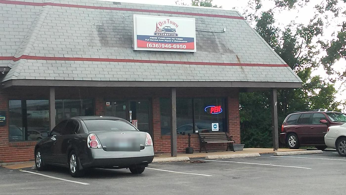The Old Town Automotive storefront, with the shop sign above the porch and the OPEN neon in the window